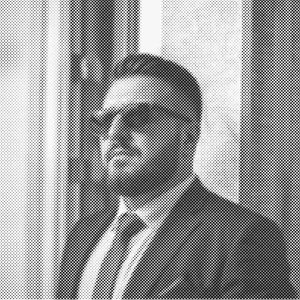 Halftone portrait of Ömer Yanbaş in a dark suit and sunglasses, standing beside a window.